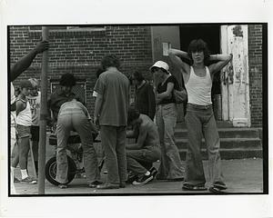 Group of people working on a scooter in a courtyard