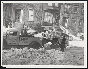 Police Tow Away Car of unlucky motorist to make way for snow clearance work yesterday on Brimmer street. In background is the home of Rear Admiral Richard E. Byrd, Arctic explorer.