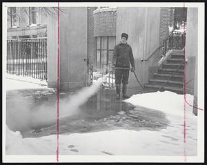 Fighting Water With Water. Ernest Isnor, superintendent at 270 Beacon St., used hot water to rid the sidewalk of frozen water yesterday. He cleared an inner terrace as well.