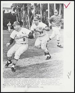 Running Down the Manager--St. Louis Cardinals manager Red Schoendienst, left, is tagged by catcher Tim McCarver as the team drilled in running down trapped baserunners at spring training camp in St. Petersburg today. In background third baseman Ken Boyer runs in to protect the plate. Schoendienst was taking the part of the baser runner in the drills.