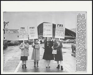 New York – Wives Picket Airline – Four women, who identified themselves as wives of flight engineers employed by Trans World Airlines, picket the airline outside the old terminal building at New York’s Idlewild airport today. They said they were protesting the possibility that their husbands might lose their jobs under a program whereby pilots were being trained in the duties of flight engineers. From left are Mrs. Hubert Robinson, Mrs. William Crickman, Mrs. Howard Nann and Mrs. Frank Metro.