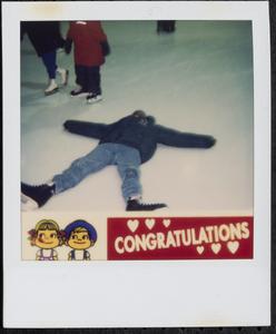 Boy laying on ice rink