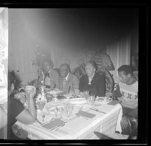 A group of people are seated eating at a dining table