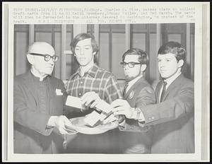 Pittsburgh, Pa: Msgr. Charles O. Rice, passes plate to collect draft cards from (l to R) Keith Bromberg, Edmund Fuller, and Ted Marsh. The cards will then be forwarded to the Attorney General in Washington, in protest of the draft.