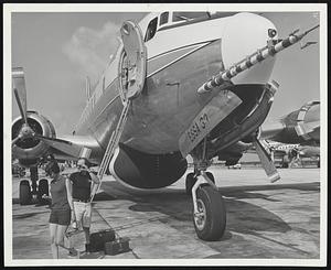 Dr. and Mrs. Joseph Prospero of the University of Miami leave Research Flight Facility plane at conclusion of a mission. Needle-like object in nose of plane is gust-probe equipment.