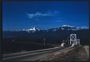 Road and Revelstoke Suspension Bridge with hills and mountains in background, Revelstoke, British Columbia