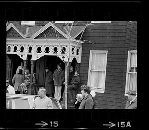 People on porch and outside house