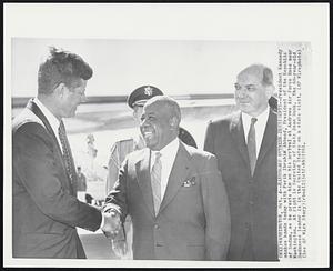 Handshake Between Presidents-- President Kennedy shakes hands today with Ferik Ibrahim Abboud, President of the Republic of Sudan, as he greets him on his arrival at Andrews Air Force Base near Washington. At right is Secretary of State Dean Rusk. The 60-year-old Sudanese leader is in the United States on a state visit.
