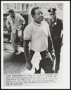 Going to Hearing - Rev. Ralph David Abernathy (center) head of the SCLC and aide Hosea Williams (left) are escorted to a hearing where both were held over for court action under $50,000 bond each.