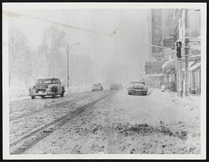 Heavy Snow Shrouded Boston Common as cars inched down Tremont St. at height of yesterday's storm. Boston streets were almost deserted as heavy snow covered icy patches left by previous blizzards.