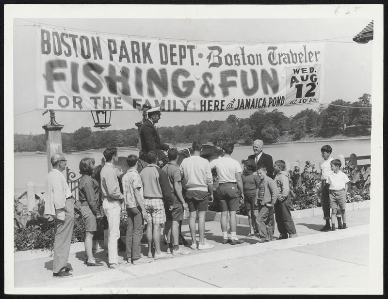 Tomorow's Fishing Rodeo at Jamaica Pond is discussed by Officer Herbert Stow and Park Supt. Pat Ryan as some of the many youngsters who will be there as questions.