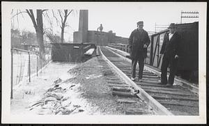 Two mill workers on paper mill track trestle