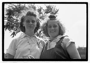 Two young women holding horseshoes
