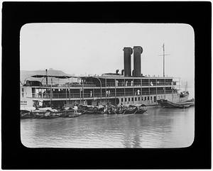 Steamship with small ships tied to it