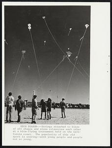 High Season – Strings attached to kites of all shapes and sizes criss cross each other at a kite flying tournament held on the California coast. The popularity of this old sport is soaring – with young people and people not so young.