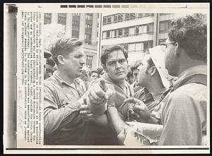 Co-Workers Think Otherwise--an irate construction worker is restrained by fellow workers as he took offense at an Associated Press photographer who was photographing a heated discussion between the worker and an unidentified black student, right, outside the Civic Center in Chicago yesterday. The construction workers are demonstrating against black workers' demands to be hired in the construction union as journey-men.