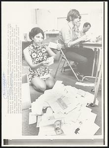Protest Money--Peggy Shaker, left, chief of the volunteers at the Vietnam Moratorium Committee headquarters assists her staff in sorting the contributions arriving in Washington last week. The mail and money pouring into the office of the committee have nearly tripled since President Nixon told a news conference September 27th that he would not "under no circumstances whatever” be affected by the planned student protest.
