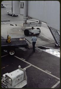 Airport employee on the tarmac by a jet bridge