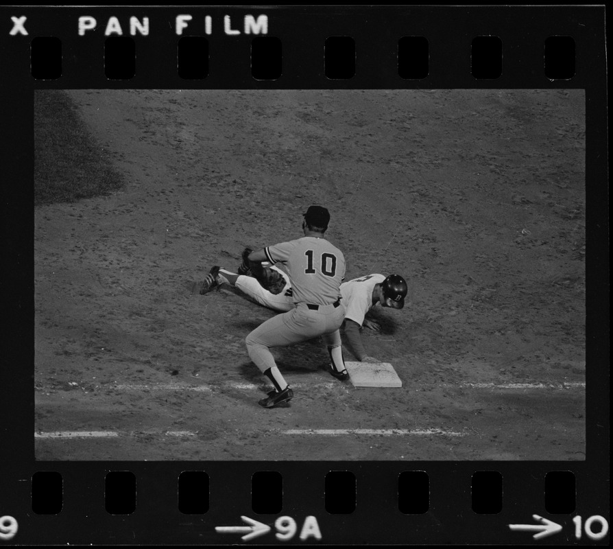 New York Yankees first baseman Chris Chambliss (#10) awaits an attempted pick-off throw, while Red Sox base runner Rick Burleson (#7) slides back towards first base