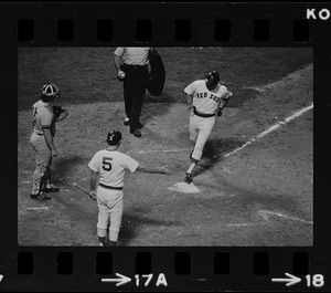 Unknown Boston Red Sox player (#5) gets ready to congratulate unknown teammate crossing home plate following home run as New York Yankees catcher Thurman Munson (#15) look on
