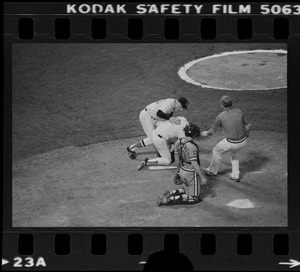 Red Sox batter Rick Burleson (#7) kneels on ground (after being hit with a pitch by Texas Rangers pitcher Doc Medich in the bottom of the 7th inning) as Red Sox coach Walt Hriniak and the Red Sox team trainer approach and Texas Rangers catcher Jim Sundberg (#10) kneels at home plate