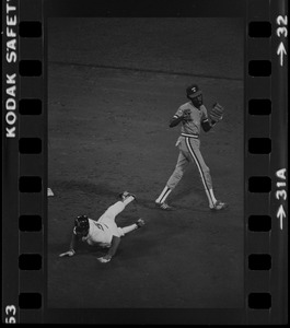 Texas Rangers shortstop Nelson Norman (#4) and sliding Boston Red Sox base runner Bob Watson (#5) both look back towards first base on an attempted double play