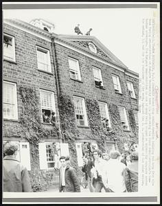 Students stand atop administration building and hang from windows during demonstration at Rutgers University here 5/4 protesting the Nixon Administration's Cambodian adventure. The Rutgers demonstration is one of many being staged on university campuses across the nation, 5/4 and for the remainder of the week, against the U. S. penetration of the Asian nation.