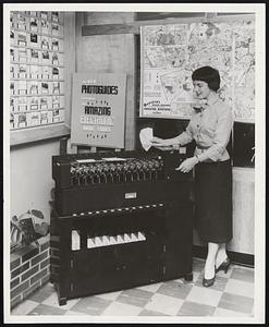 New Home-Matic Selector, designed for Town and Country Homes, Inc., by Underwood Corporation, is operated by Cathy Cameron at firm's headquarters, 256 Boylston St. Town and Country, in acquiring unique machine, scores another "first" in real estate field. It matches customers' needs to property.