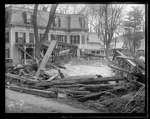 Debris surrounding a wrecked bridge, possibly from a natural disaster