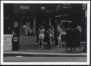 Three women by payphones in front of Zipa Jewelry