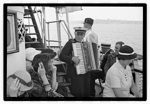 Passengers on a ship, accordion player in center