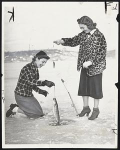Pick The Fish Who Eats Spinach. Kay Lyons (left) and Margaret Kelly, of the Fishing Club of Our Lady of Good of White Plains, compare their catches made through the ice at Lake Carmel here Jan. 8. The collegiate fishing organization held its initial fishing trip here on that date.