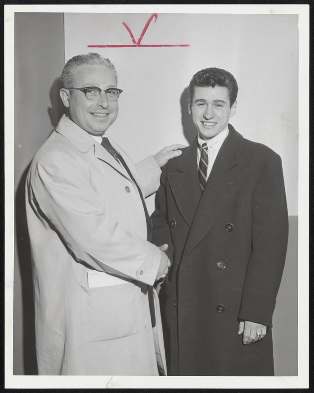 New Champion accepts congratulations of ex-champion as Joe Sapanaro, Jr., of East Boston is welcomed at Boston Airport by his father after winning NCAA pocket billiards crown at East Lansing, Mich. The elder Sapanaro once held similar title. Young Joe is student at Suffolk University.