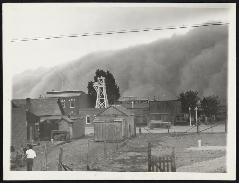 Dust -- New Mexico Style. Clayton, N.M. -- Sweeping across farm lands like a gigantic tidal wave, a dust storm rolls into Clayton, burying it beneath a cloud of swirling, wind-blown earth. Storms such as this are frequent in this "dust bowl" community, but seldom, is the approach of a storm so well portrayed as in this photograph, made by an amateur photographer who considered it "nothing unusual".