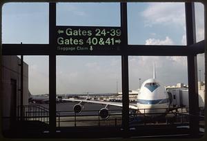 Airport gate, airplane in background attached to a jet bridge