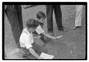 Two boys looking at a thrown knife