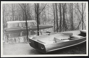 Grounded Boat and semi-submerged car sit in the front yard of David Michelson of Bonnievale Dr., Bedford. Flooding came from Concord River.