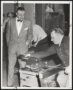 A Master Glass Blower, called a "gaffer," gives final shaping to crystal bowl for the harmonica. From the glass works, the novel instruments was taken to an organ-maker where the keyboard and cabinet were fashioned.