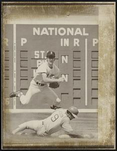 Red Sox 2nd baseman Doug Griffith leaps over sliding Reggie Jackson of A's attempting to double up Tommie Davis at 1st in 3rd inning action at Fenway Park 8/12.