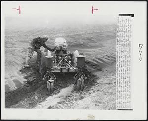 Storm Aftermath--L. P. Engle, of Abilene, works to get his small tractor out of three feet of dust following the storm that hit the state of Kansas yesterday. At right can be seen the top soil blown into a ditch alongside the farmer's field. Engle had 160 acres of wheat before the storm but when it was over, his quarter section of land was bare. He said he'll plant row crops on the ruined land. Engle experienced similar dust storms in the 1930s.