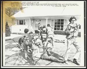 A group of antiwar demonstrators stage mock guerrilla warfare on the lawn of Defense Secy Laird's home 4/26. The group put a Viet Cong flag on the lattice work beside the door.