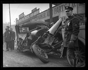 Police standing in front of a car wreck