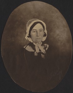 Early photo of middle-aged woman in white bonnet and dark dress