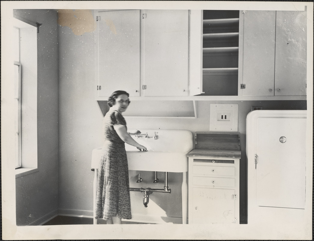 A young woman inspects the modern kitchen in one of the East Cambridge federal apartments which will be finished next week