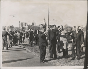 President Kennedy is shown as he made an unscheduled stop on Storrow Drive across the river from Harvard where he is shown looking over the proposed Kennedy Library sight with Harvard officials