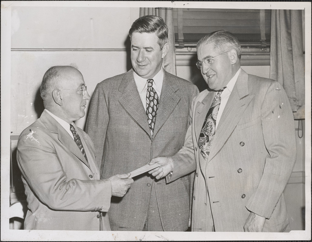 John A. DeLoria (left), retiring grand knight of North Cambridge Council, Knights of Columbus, is given purse of money by John S. O'Quinn (right), who is the grand knight-elect