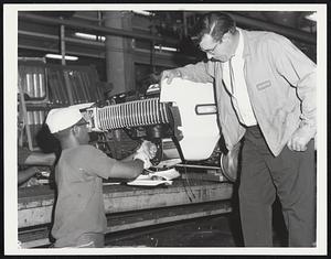 Watching the Worker. At The Dearborn, Mich., assembly line of the Ford Motor Company, Ralph Copley, suervisor, looks on as a worker, Freddie A. Woodson, applies his efforts to car construction.