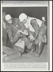 Stopping a Demonstrator -- Two policemen restrain a flag decorated demonstrator during the outbreak of violence in Washington tonight. A rock-throwing crowd of demonstrators marching to the South Vietnam embassy in the nation's capitol were stopped by police with tear gas.