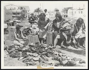 Shoes for Earthquake Victims. This open-air shop at Compton, Calif., operated by the Inglewood Auxiliary of the American Legion, provided free shoes for earthquake victims. The photograph shows business booming March 14 as needy victims helped themselves.