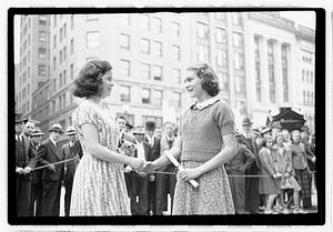 Two young women shaking hands